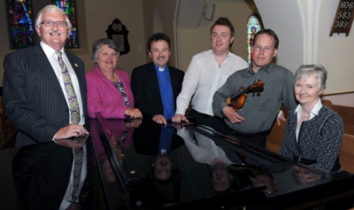 Pictured at the grand piano, at the first of three ‘Music in May’ lunchtime concerts in Christ Church Parish, Lisburn, are L to R: Councillor Ronnie Crawford, Jean Crawford, Rev Paul Dundas (Rector), Richard Yarr (Christ Church Organist),  Alan McClure (Violinist) and Elizabeth Bicker MBE (accompanist). 